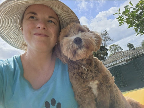 Ros with one of the cavoodles in the pack, in the garden at her place in Lota